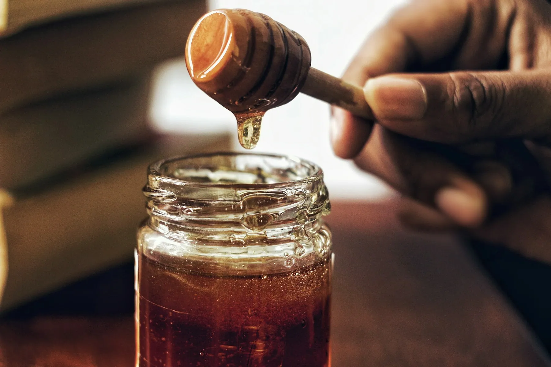 蜜勺与玻璃罐中的金色蜂蜜